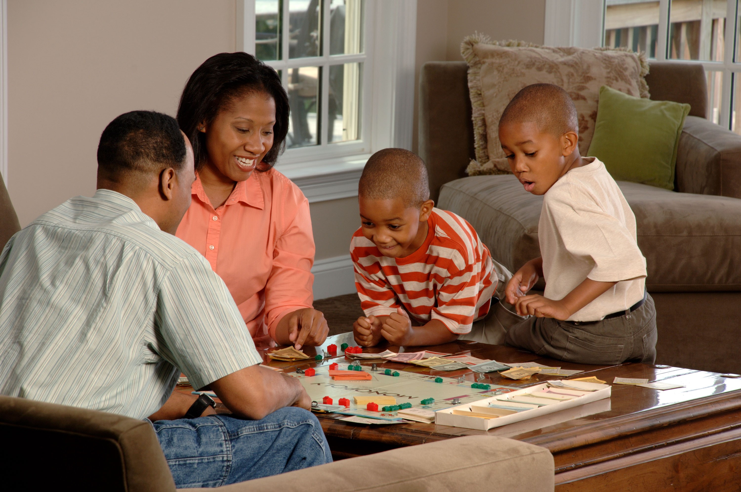 两个成年人和两个孩子玩棋盘游戏。