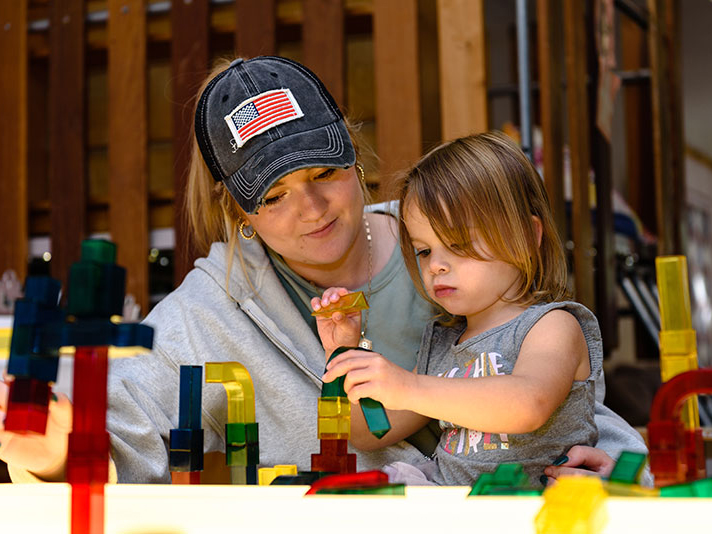 成人和学龄前儿童玩积木。
