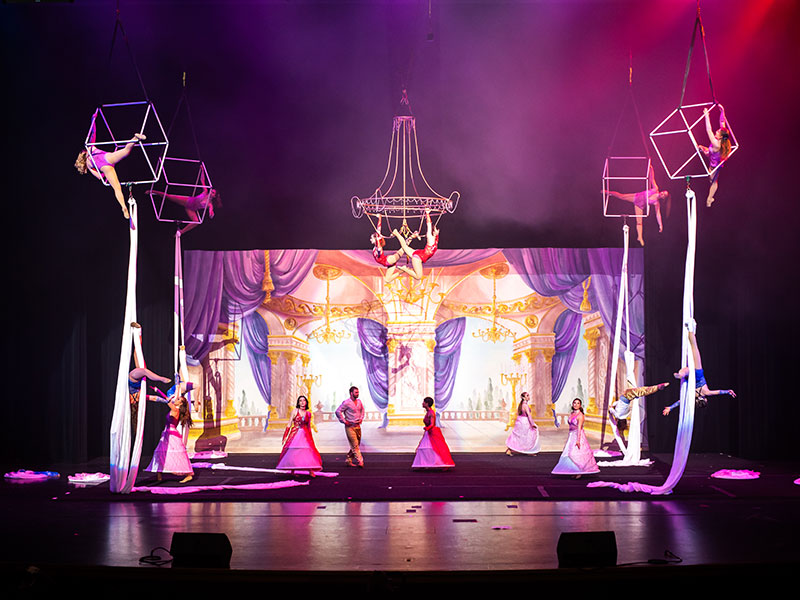 精心设计的舞台场景，盛装的空中表演者和舞者。