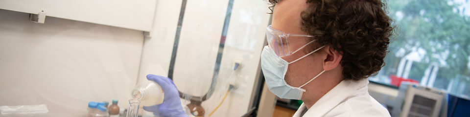 一个学生在实验室里实验液体。