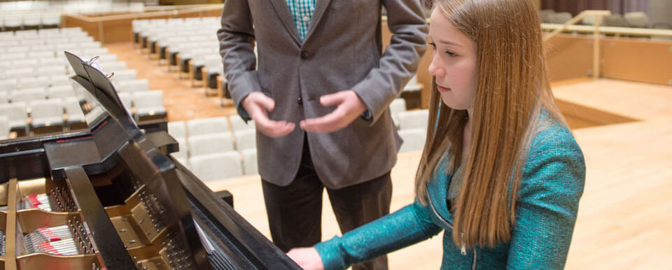 一个钢琴家在另一个学生唱歌时给他伴奏。