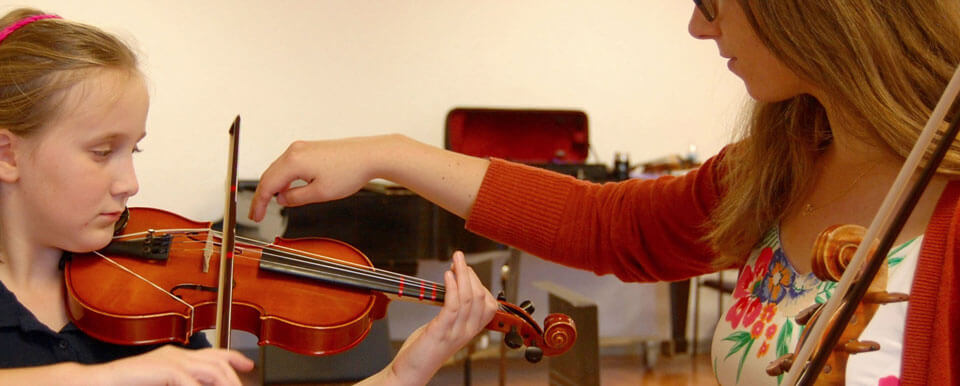 实习教师给她的学生上小提琴课。