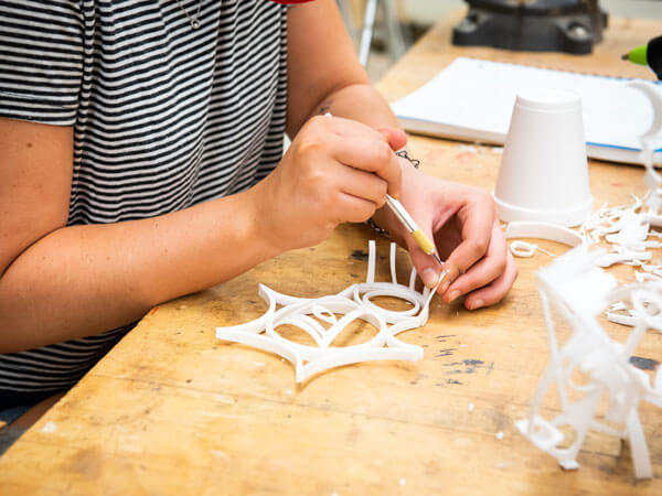 一名学生在3D基础课上用塑料做雕塑。