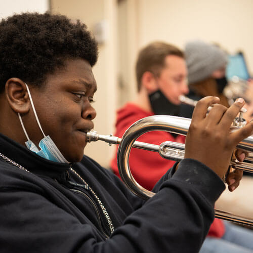 一个学生在爵士乐团演奏小号。