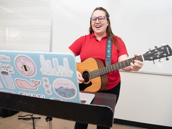 音乐治疗研究生在视频通话中弹吉他。