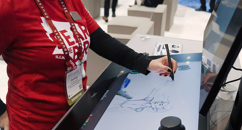 在一次会议上，一名女性正在用互动笔在一块大平板上描绘一个人。