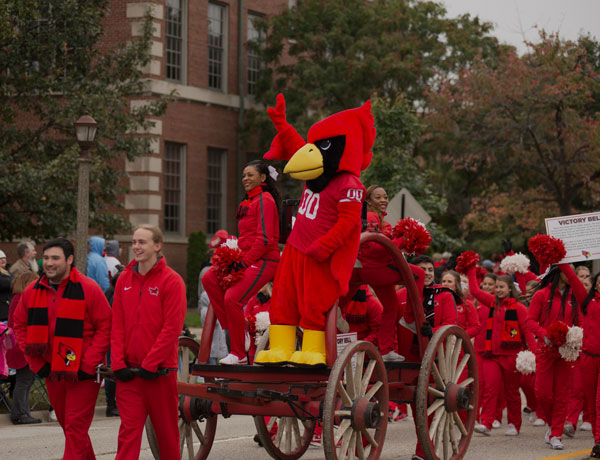 雷吉（Reggie）在返校游行期间，红鸟队站在啦啦队中的战车上。
