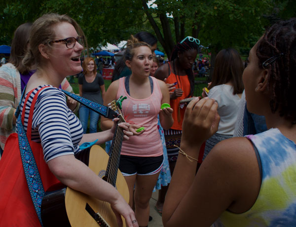 一群学生演奏乐器并在四边形上唱歌。