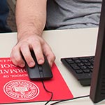 男性手握电脑鼠标。