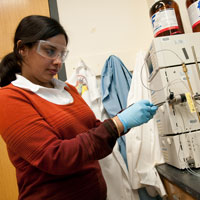 一个学生工作时佩戴安全眼镜和手套与实验室设备。