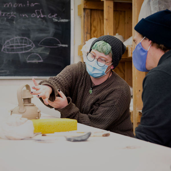 陶瓷的学生讨论他们的工作和他们的教授。