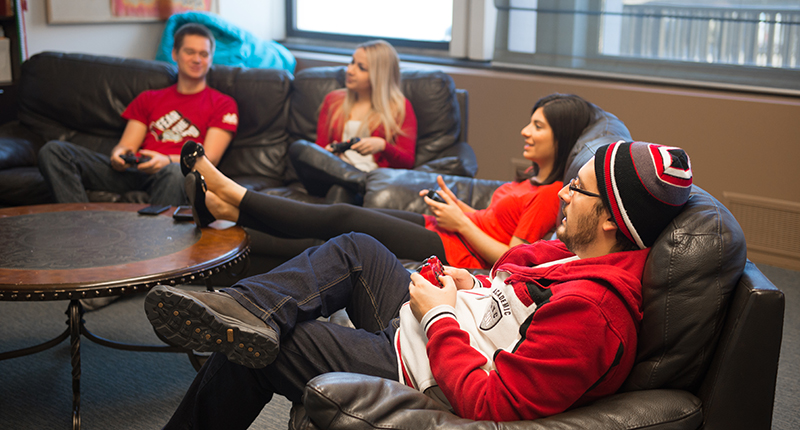 2022世界杯播出时间国际学生放松在沙发上,玩视频游戏。