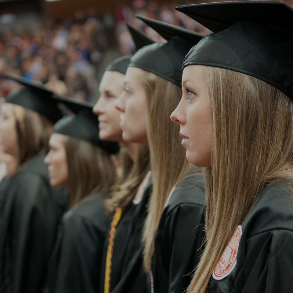 学生帽长袍站在毕业典礼。