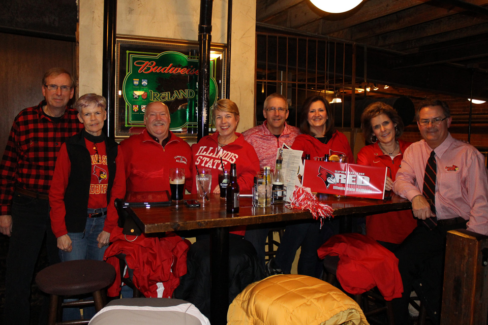 一群穿着红色衣服的人在餐桌旁微笑