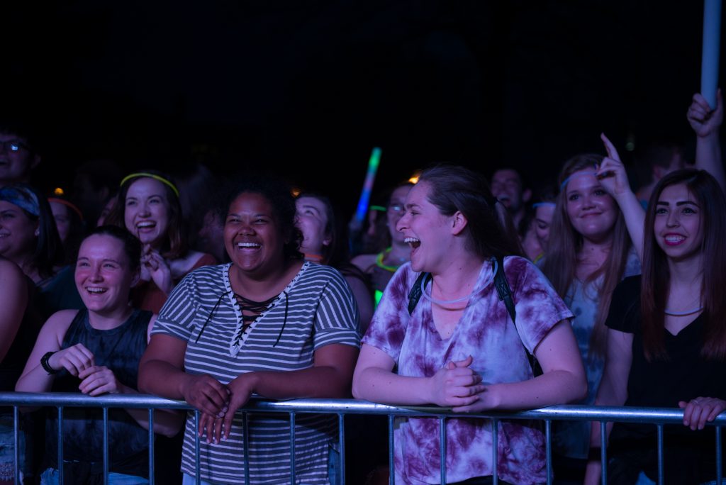一群学生和glowsticks大微笑享受一场音乐会