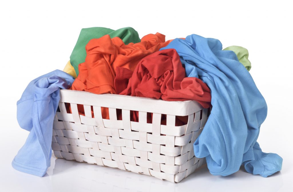 色彩斑斓的脏衣服在洗衣篮孤立在白色背景