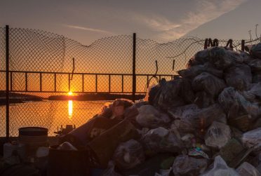 红鸟撞击封面2018年秋季无文字密西西比河的图片，背景是一座桥，前景是一堆垃圾