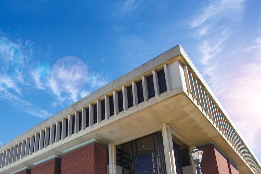米尔纳图书馆外部建筑的一角，蓝天和缕缕云在背景中