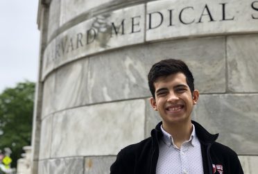 Basheer Becerra站在哈佛医学院的标志前。