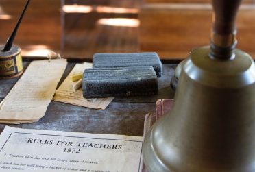 伊利诺伊州校友杂志2014年冬季的封面展示了旧学校的课堂物品，其中包括一份名为《1872年教师规则》的清单