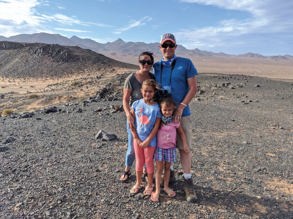 杰夫·威廉姆斯和他的妻子和两个孩子站在山脉。
