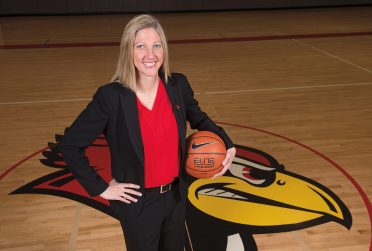 伊利诺伊州女子篮球主教练克里斯汀·吉莱斯皮在红鸟球馆的中场拿着篮球