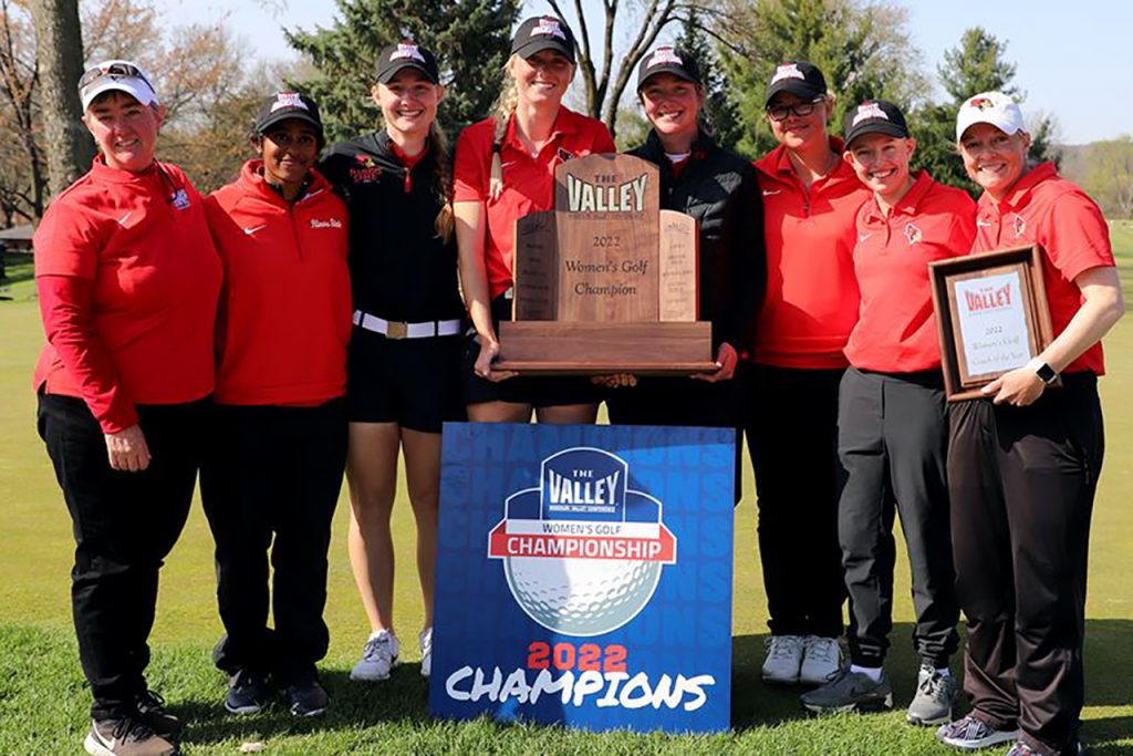 红鸟女子高尔夫球队赢得2022年密苏里河谷锦标赛冠军，站在奖杯旁。