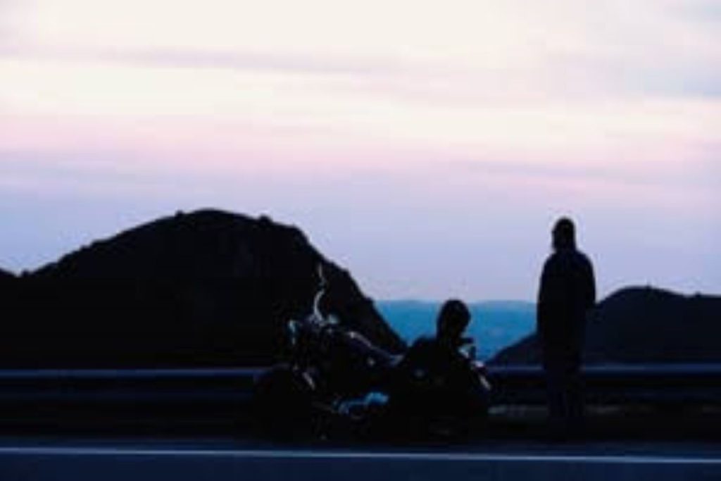 人站在摩托车望多山的地平线