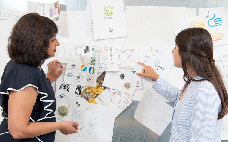两个人站在白板上覆盖着的想法,颜色,和论文