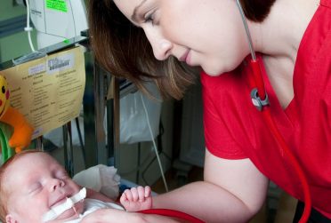 护理系校友珍妮萨·詹金斯治疗婴儿的照片登上了伊利诺伊州杂志2010年秋季封面