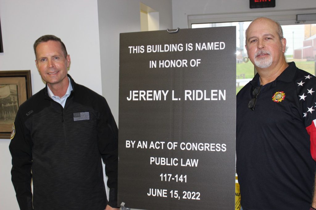 罗德尼·戴维斯和詹姆斯·基思带着纪念杰里米·里德伦的牌匾