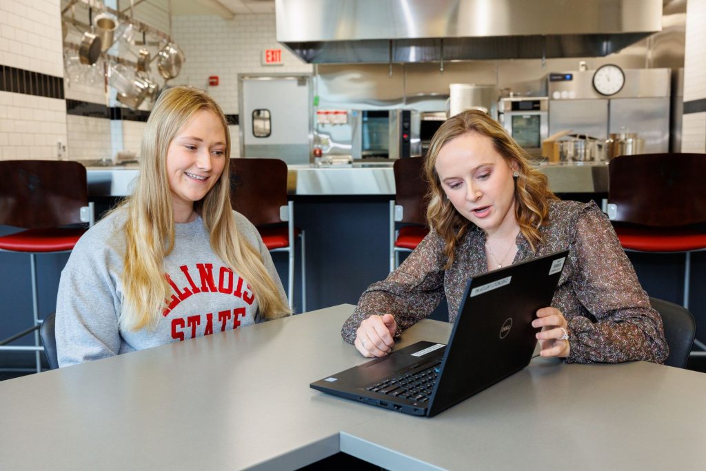 学生Gabby Stopka和注册营养师Morgan Harm在计划一周的膳食时看着电脑屏幕。