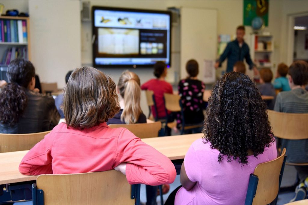 学生坐在教室里听他们的老师。