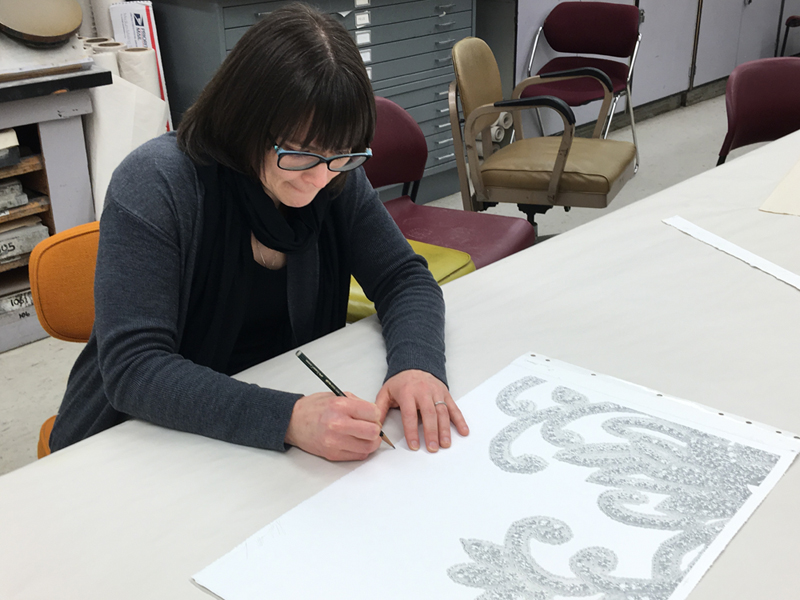 艺术家斯蒂芬妮班轮坐在一张桌子,她打印签字。