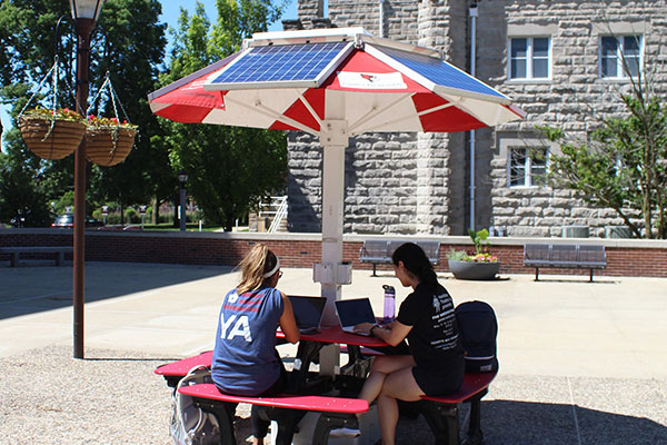 学生们坐在太阳能野餐桌旁。