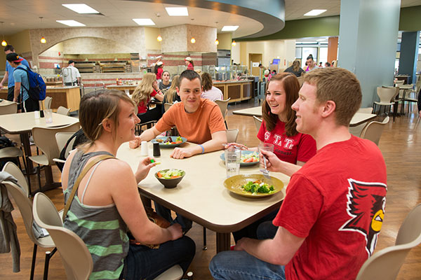 一群学生在餐桌旁聊天。