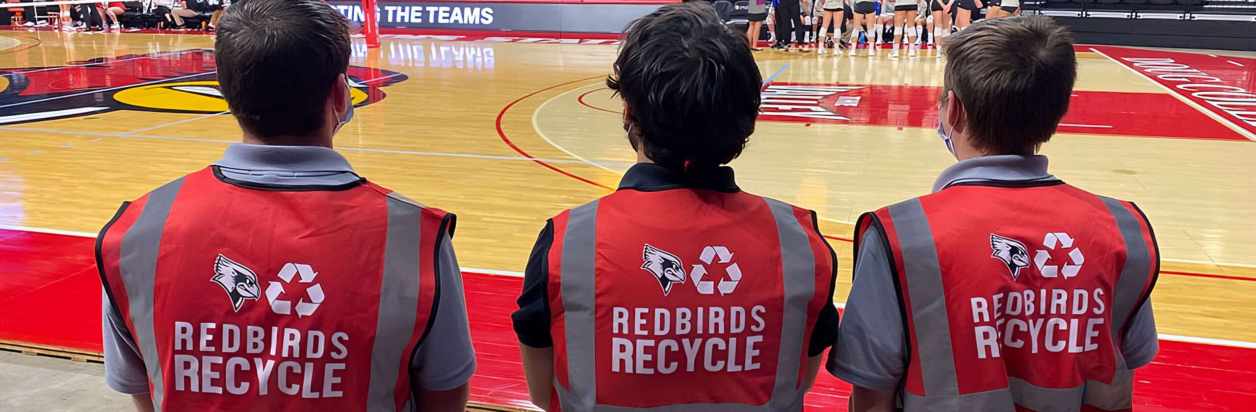 三名红鸟回收的成员一起站在红鸟竞技场的一场篮球比赛中。